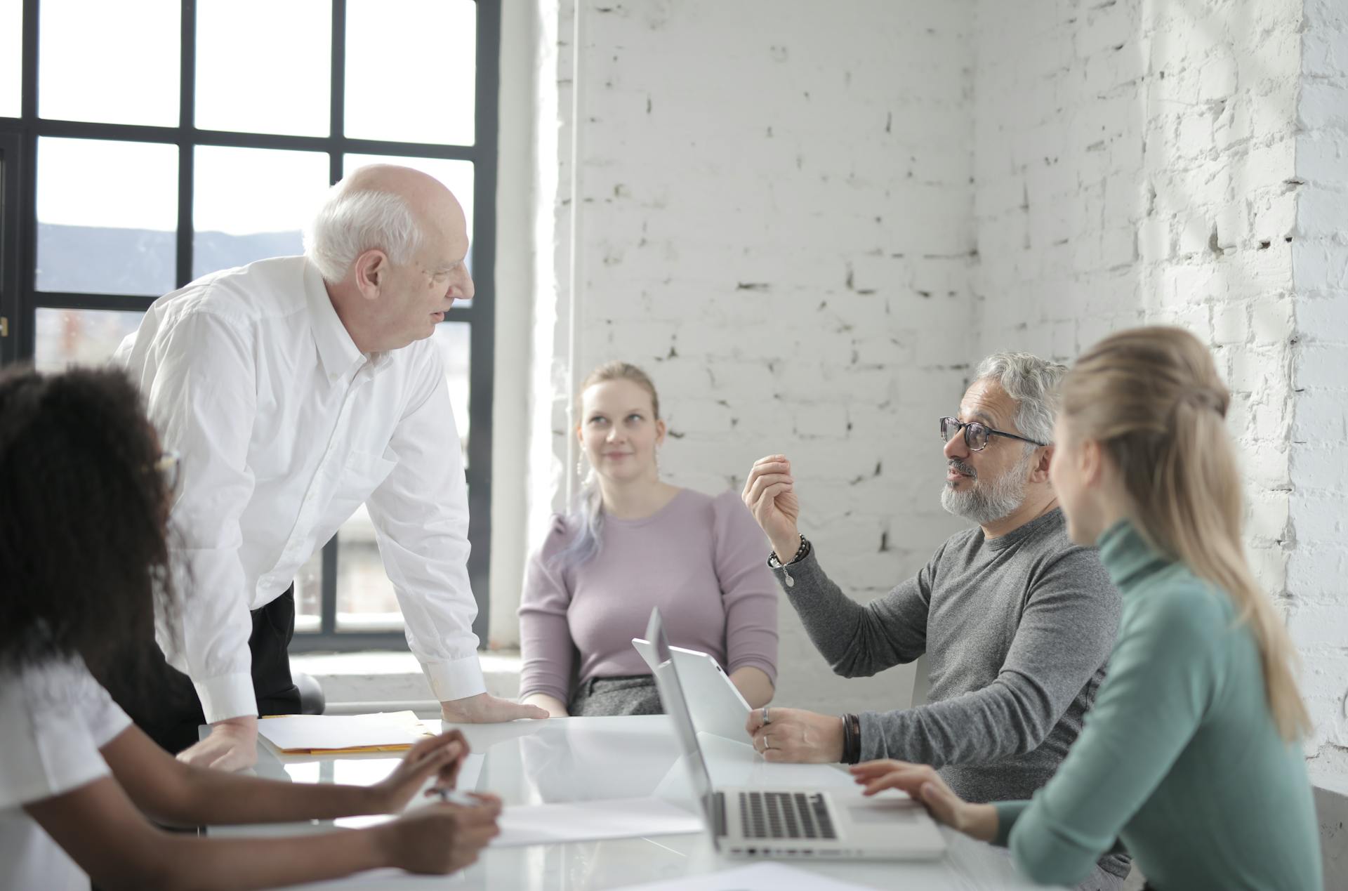 Diverse group of professionals engaged in discussion in a modern office setting.